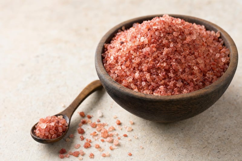 Bowl of coarse red Hawaiian alaea sea salt with a wooden spoon